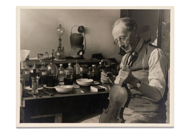 Alfred Phillips Hill working on a violin at his workbench